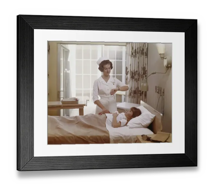 Framed Print : Female nurse checking pulse of girl in bed