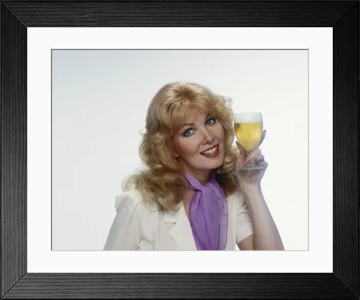 Framed Print : Young woman holding beer glass, smiling, portrait Framed Print : Young woman holding beer glass, smiling, portrait