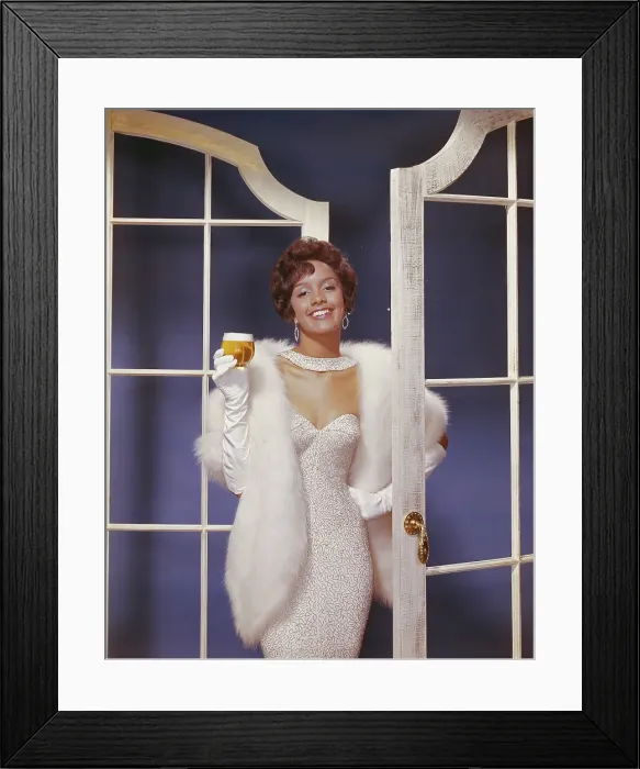 Framed Print : Young woman wearing fur jacket holding beer glass, smiling, portrait Framed Print : Young woman wearing fur jacket holding beer glass, smiling, portrait