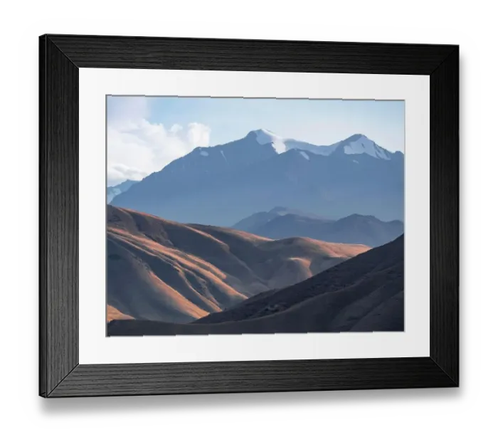 Framed Print : View over eroded mountainous landscape with brown hills, high mountains with snow in the back, Konorchek Canyon, Chuy, Kyrgyzstan Framed Print : View over eroded mountainous landscape with brown hills, high mountains with snow in the back, Konorchek Canyon, Chuy, Kyrgyzstan