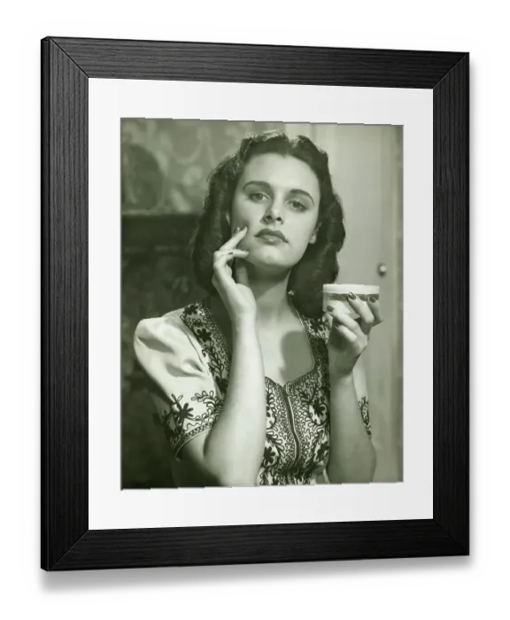 Framed Print : Young woman applying creme on face, (B&W), portrait Framed Print : Young woman applying creme on face, (B&W), portrait