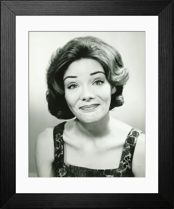 Framed Print : Young woman looking amused, posing in studio, (B&W), portrait Framed Print : Young woman looking amused, posing in studio, (B&W), portrait