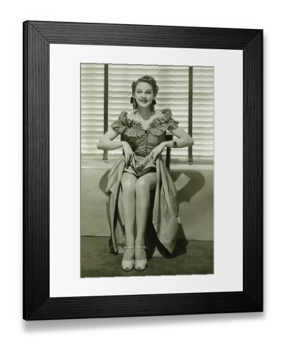 Framed Print : Young woman sitting on chair, showing off her legs, (B&W) Framed Print : Young woman sitting on chair, showing off her legs, (B&W)