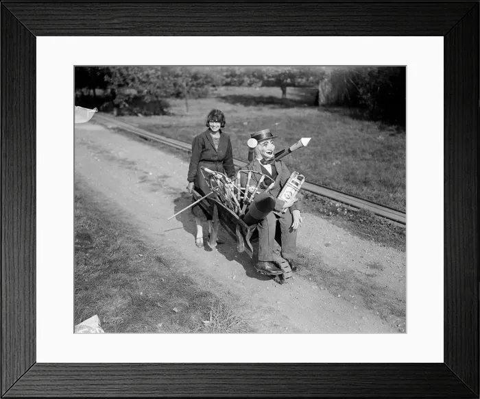 Framed Print : Good Guy. 1929: A young woman pushing a guy and a load of fireworks in
