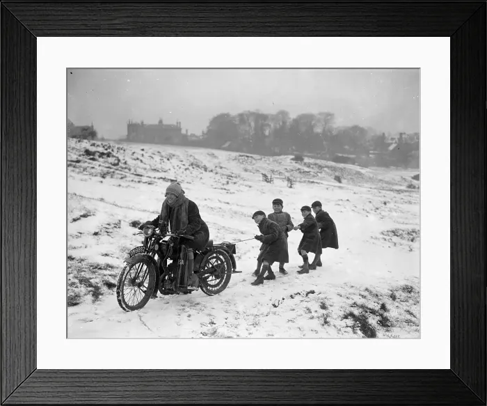 Framed Print : Snow Ride. January 1926: Youngsters being pulled along by a girl on a motorbike Framed Print : Snow Ride. January 1926: Youngsters being pulled along by a girl on a motorbike