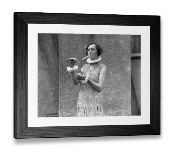 Framed Print : Ruffles. circa 1926: A woman smoking a large cigarette Framed Print : Ruffles. circa 1926: A woman smoking a large cigarette