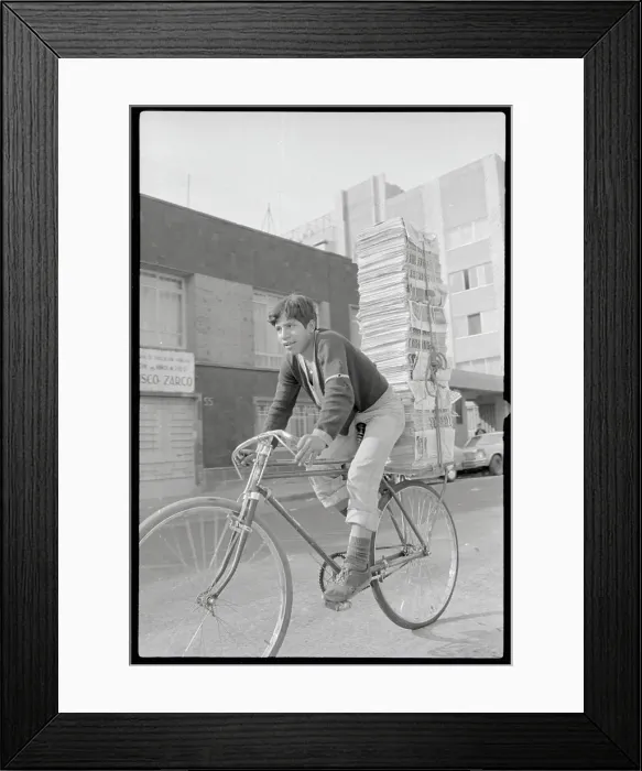 Framed Print : Boy Riding Bicycle with Tall Stack of Newspapers Framed Print : Boy Riding Bicycle with Tall Stack of Newspapers