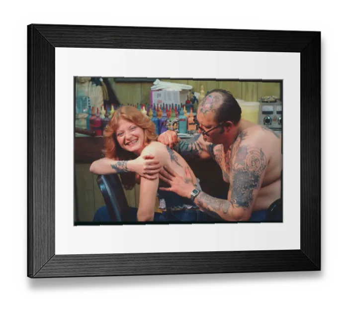 Framed Print : Tattoo Artist Working on Young Woman Framed Print : Tattoo Artist Working on Young Woman