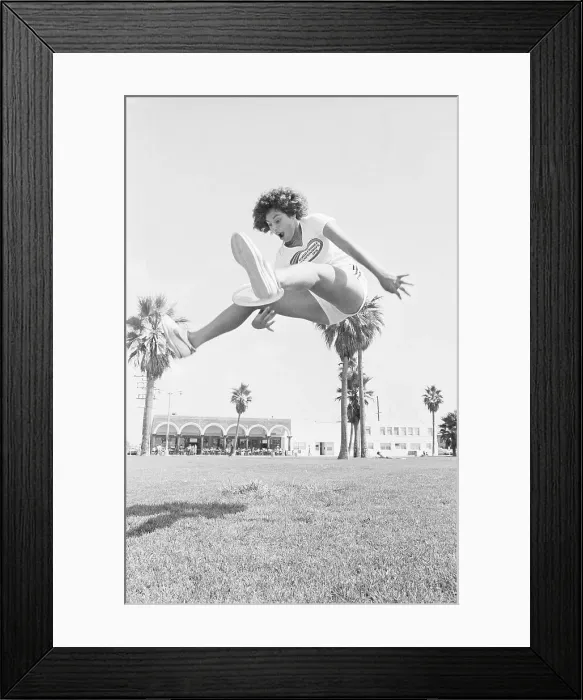 Framed Print : Laura Engel Catching Frisbee Through Her Legs