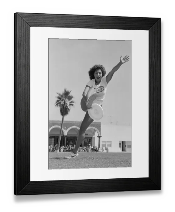 Framed Print : Laura Engel Catching Frisbee Through Her Legs