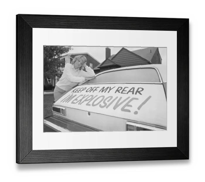 Framed Print : Woman Leaning on Ford Pinto with Warning Sign