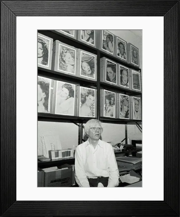 Framed Print : Andy Warhol Sitting on Desk in His Studio Framed Print : Andy Warhol Sitting on Desk in His Studio