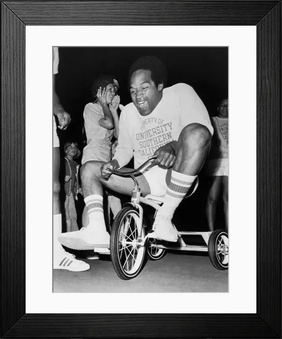 Framed Print : O.J. Simpson Pedaling a Tricycle Framed Print : O.J. Simpson Pedaling a Tricycle