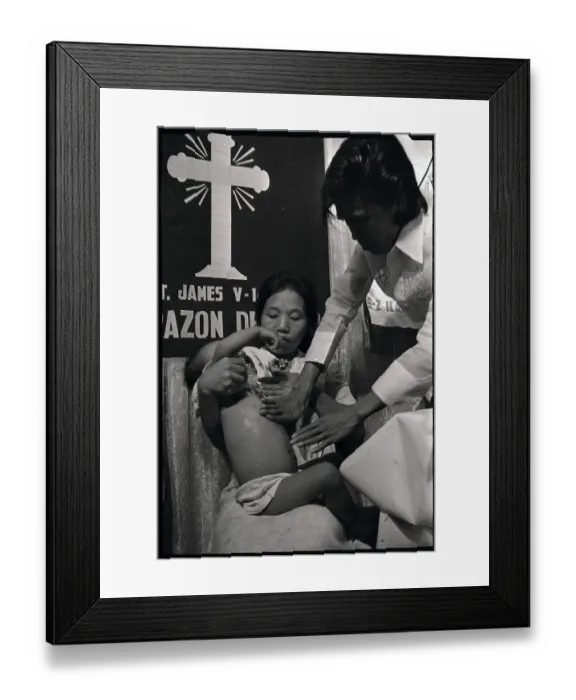 Framed Print : Alex Orbito is Shown Examining a Baby Framed Print : Alex Orbito is Shown Examining a Baby