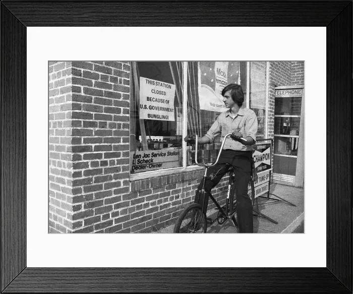 Framed Print : Gas Attendant Reading Sign at Station Framed Print : Gas Attendant Reading Sign at Station