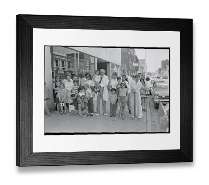 Framed Print : Doctor Holding Child Surrounded by Workers and Patients Framed Print : Doctor Holding Child Surrounded by Workers and Patients