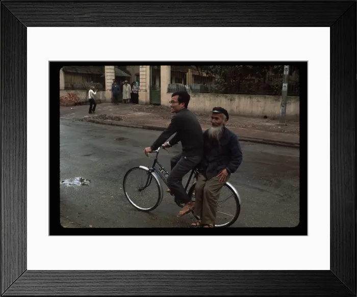Framed Print : Men Riding a Bike in Street Framed Print : Men Riding a Bike in Street