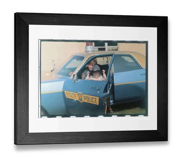 Framed Print : Female State Trooper with Son in Patrol Car
