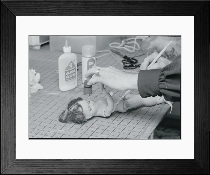 Framed Print : Woman Repairing Doll