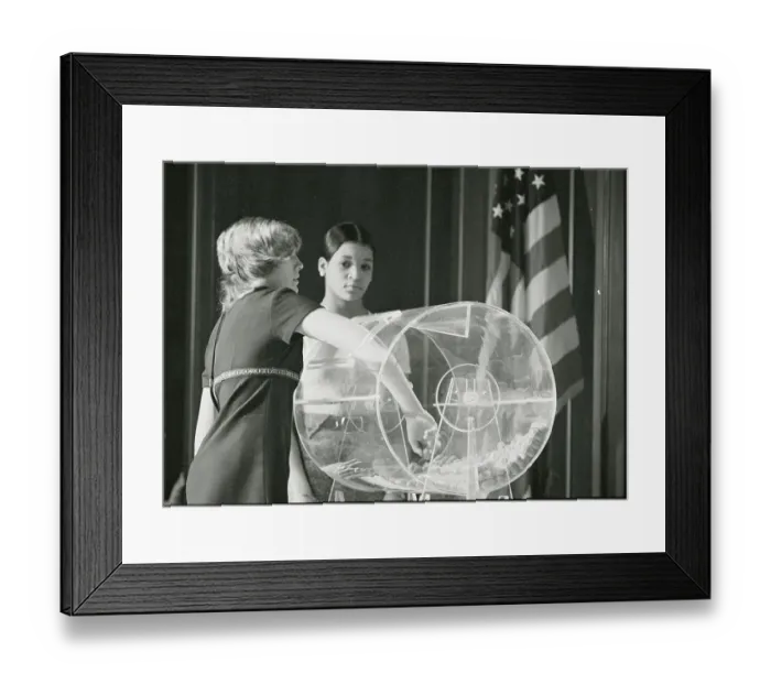 Framed Print : Woman Reaching in Wheel for Capsule Framed Print : Woman Reaching in Wheel for Capsule