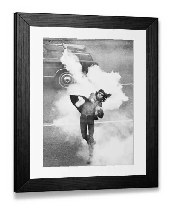 Framed Print : Anti-War Demonstrator Throwing Tear Gas
