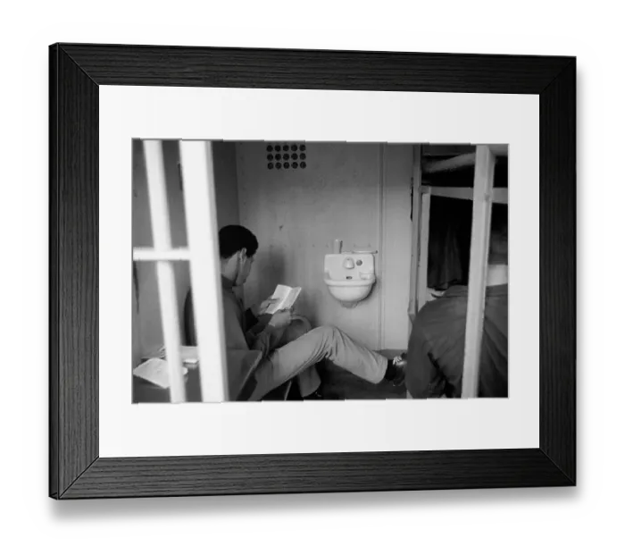 Framed Print : Prisoner Reading Book in Prison Cell Framed Print : Prisoner Reading Book in Prison Cell