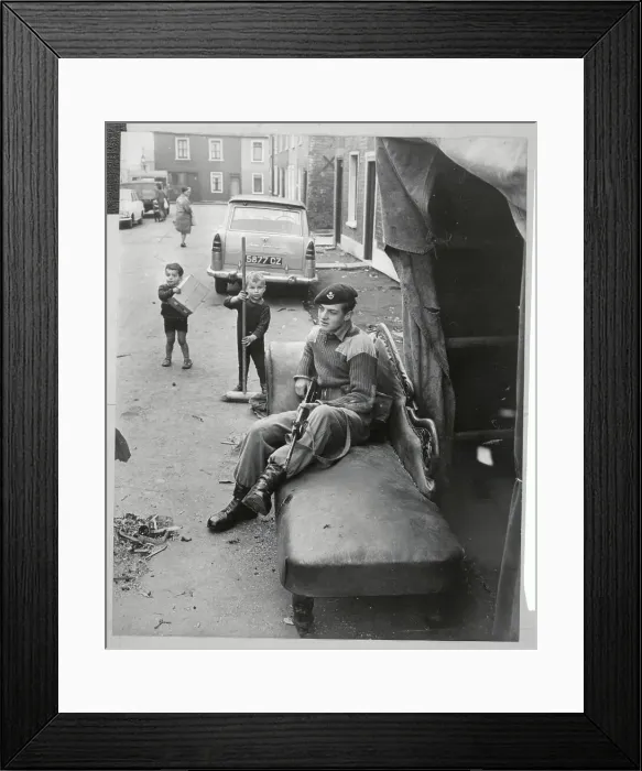 Framed Print : Children Sweeping Street While Soldier Rests Framed Print : Children Sweeping Street While Soldier Rests