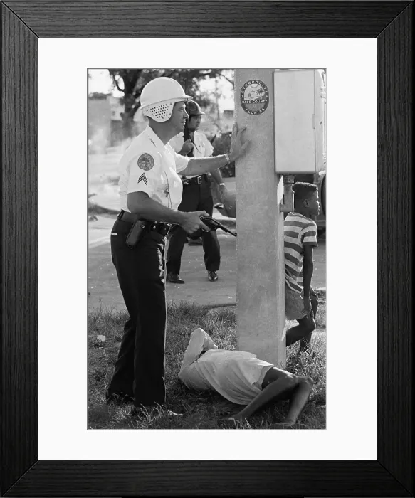 Framed Print : Armed Policeman Hovering over African American Woman Framed Print : Armed Policeman Hovering over African American Woman
