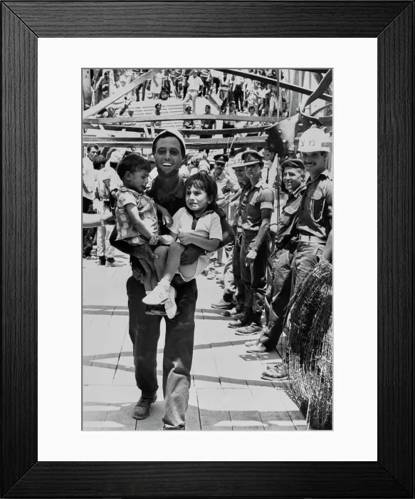 Framed Print : Man Carrying Refugee Children Framed Print : Man Carrying Refugee Children