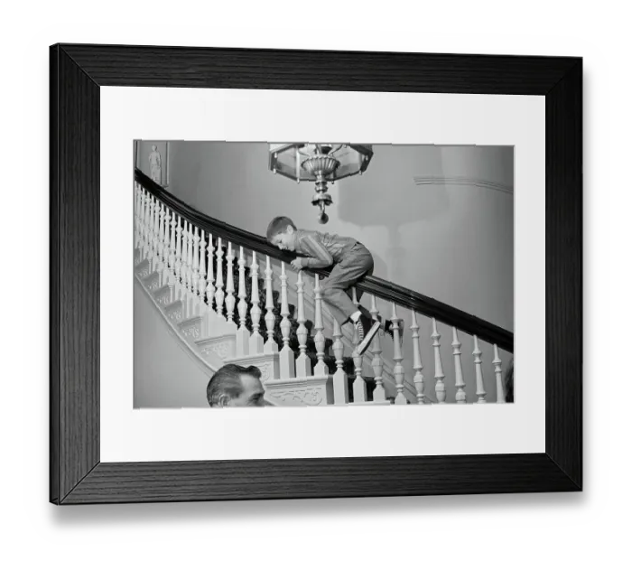 Framed Print : Ronald Reagan, Jr. Sliding Down Stair Banister