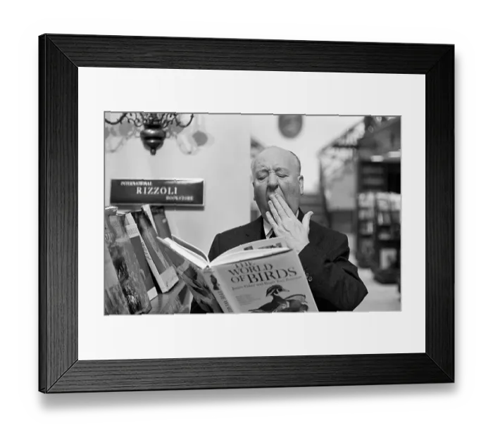 Framed Print : Alfred Hitchcock Yawning over Book of Birds Framed Print : Alfred Hitchcock Yawning over Book of Birds