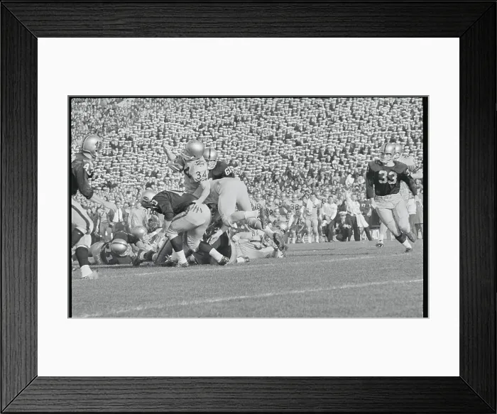 Framed Print : Football Players Tackling Their Opponent Framed Print : Football Players Tackling Their Opponent