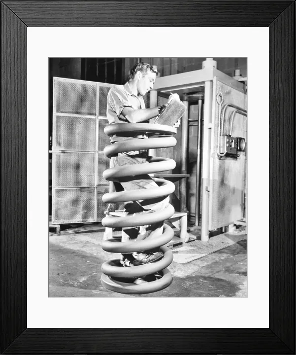 Framed Print : Man Inspecting Giant Spring Coil Framed Print : Man Inspecting Giant Spring Coil