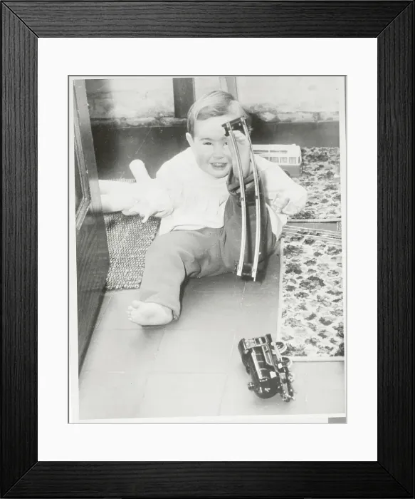 Framed Print : Baby Lifting Model Railroad Track with Foot Framed Print : Baby Lifting Model Railroad Track with Foot