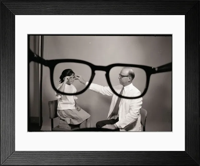 Framed Print : Doctor Puts Glasses on Girl Framed Print : Doctor Puts Glasses on Girl