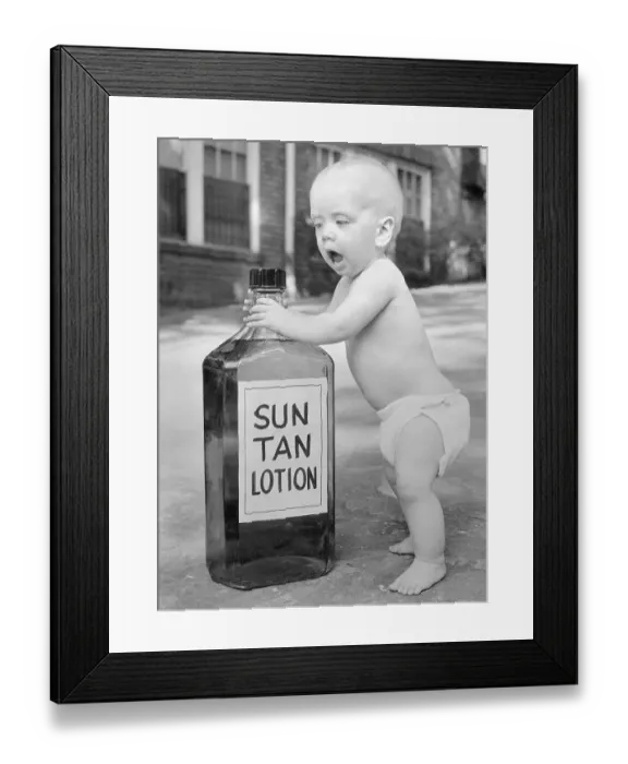 Framed Print : Baby Posing with Bottle of Sun Tan Lotion Framed Print : Baby Posing with Bottle of Sun Tan Lotion