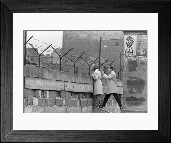 Framed Print : Young Couple Peers Over Berlin Wall Framed Print : Young Couple Peers Over Berlin Wall