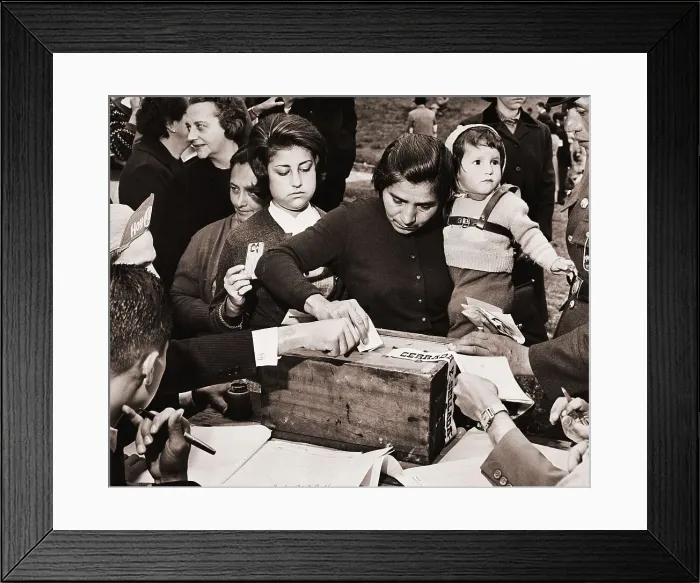 Framed Print : Woman Carrying Child Deposits Ballot Framed Print : Woman Carrying Child Deposits Ballot