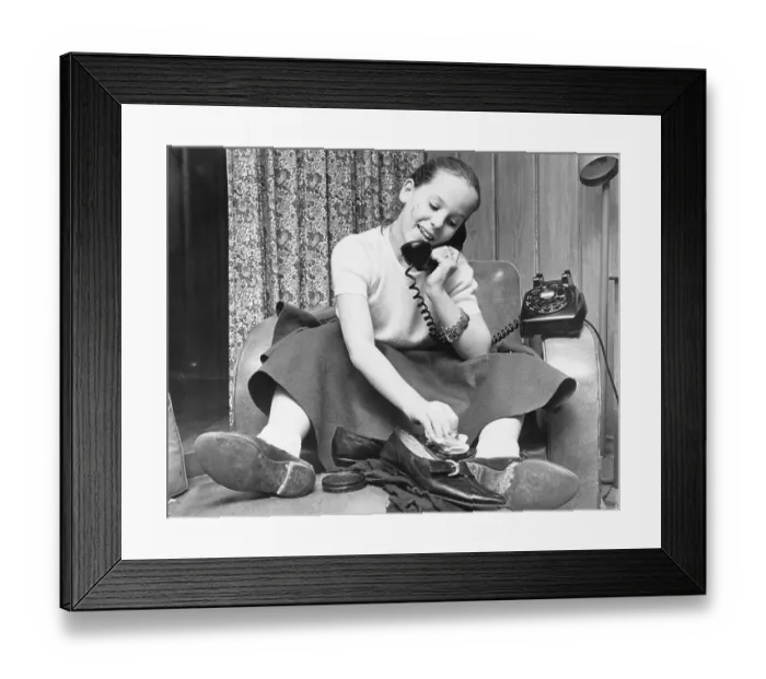 Framed Print : Teenage Girl Talks on Phone While Polishing Shoes