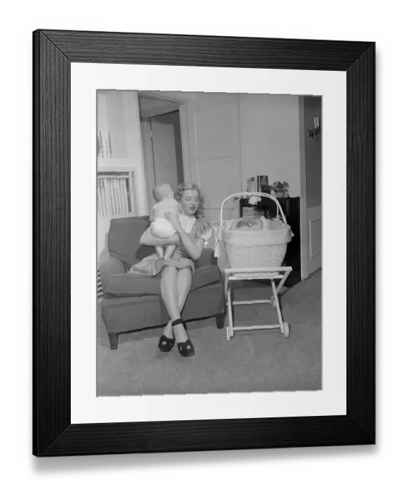 Framed Print : Marilyn Monroe Holding Baby on Couch Framed Print : Marilyn Monroe Holding Baby on Couch