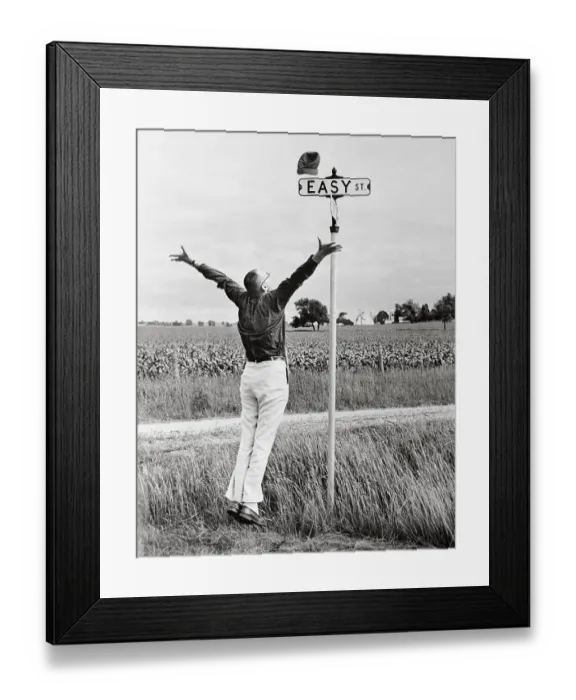 Framed Print : Man Jumping for Joy Near Sign for Easy Street Framed Print : Man Jumping for Joy Near Sign for Easy Street