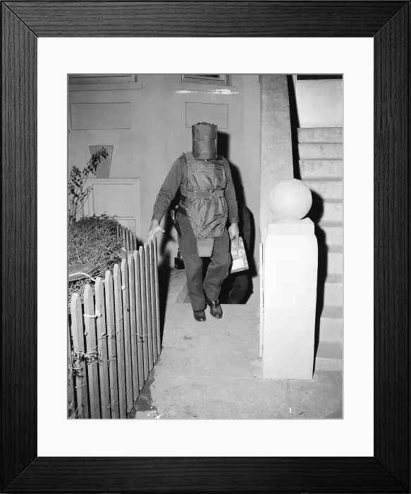 Framed Print : Policeman in Protective Gear Carries Bombs Framed Print : Policeman in Protective Gear Carries Bombs