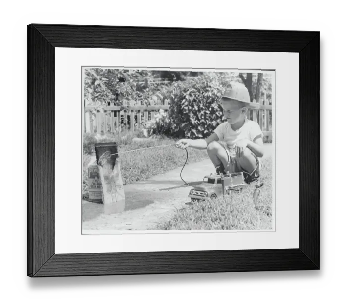 Framed Print : Boy Hosing His Makeshift Toy as a Fireman