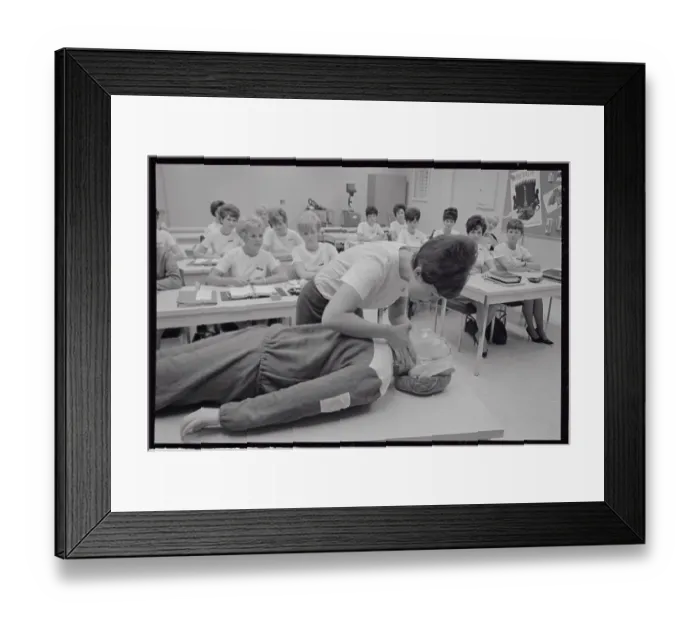 Framed Print : Medical Trainee Bending over Dummy on Table Framed Print : Medical Trainee Bending over Dummy on Table