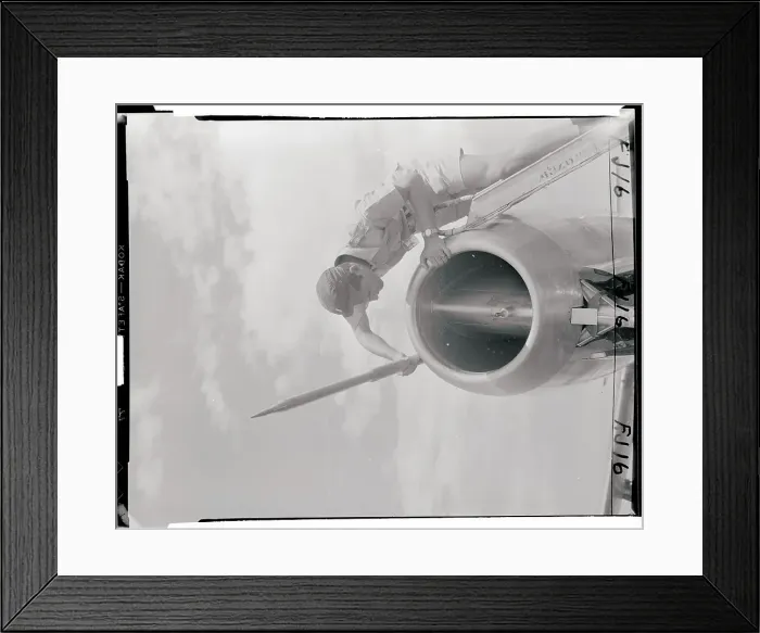 Framed Print : Man Examining a Tube on the Nose of a Jet Framed Print : Man Examining a Tube on the Nose of a Jet