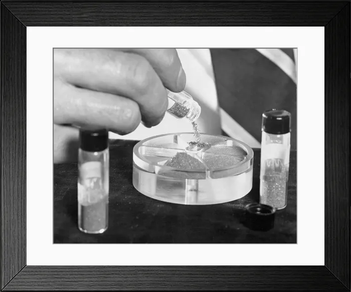 Framed Print : Scientist Pouring Manmade Diamonds into a Container Framed Print : Scientist Pouring Manmade Diamonds into a Container