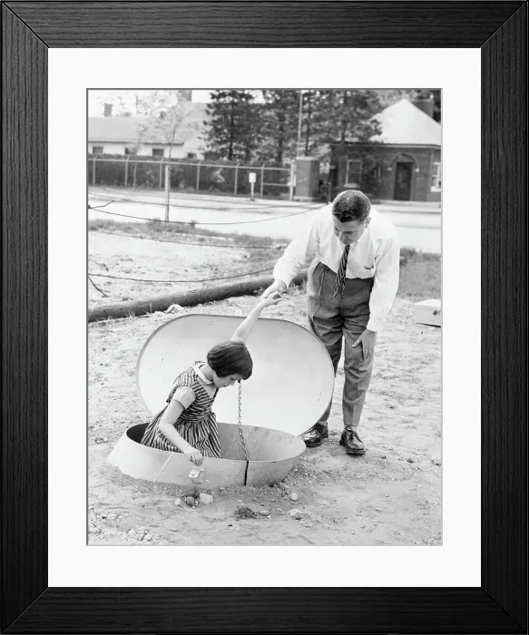 Framed Print : Man Helping Young Girl into Bomb Shelter Framed Print : Man Helping Young Girl into Bomb Shelter