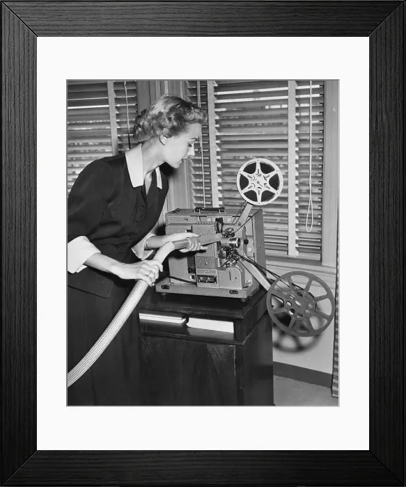 Framed Print : Woman Cleaning Film Projector with Vacuum Framed Print : Woman Cleaning Film Projector with Vacuum