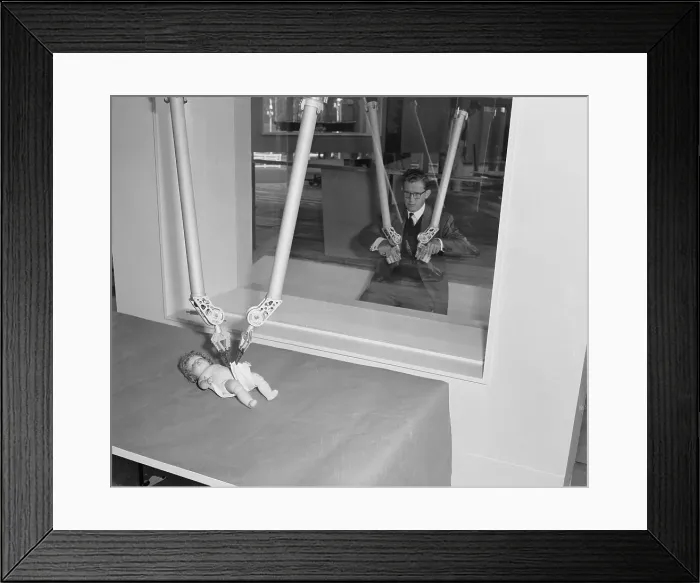 Framed Print : Man Diapering Baby Doll with Mechanical Hands Framed Print : Man Diapering Baby Doll with Mechanical Hands