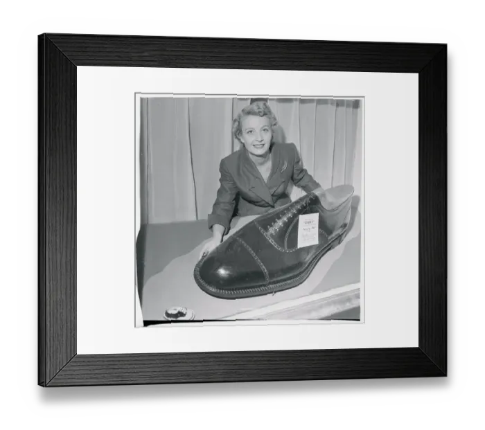 Framed Print : Woman Displaying Oversized Novelty Shoe Framed Print : Woman Displaying Oversized Novelty Shoe